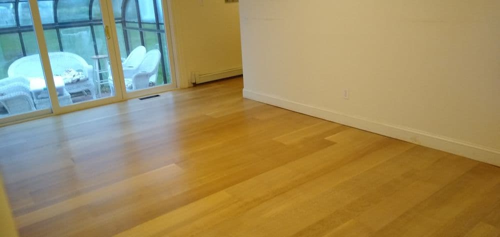 Bright interior with newly installed wooden flooring and large windows.